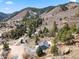 Scenic aerial view of hillside home with winding driveway surrounded by mature trees and mountain views at 508 Viola St, Palmer Lake, CO 80133