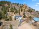 Stunning hillside home with attached garage and winding driveway surrounded by mature trees and striking rock formations at 508 Viola St, Palmer Lake, CO 80133