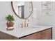 Close up of bathroom vanity with wood cabinets, white countertop, and gold fixtures at 2675 S Eudora St, Denver, CO 80222