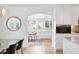 Bright dining room featuring a view to the light filled office with stylish hardwood flooring and modern cabinetry at 2675 S Eudora St, Denver, CO 80222