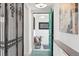 Hallway featuring tile flooring, decorative metal gate, and a view into the home's entryway at 2675 S Eudora St, Denver, CO 80222