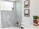 A bright, white tiled shower with gold fixtures and a window allowing natural light at 2675 S Eudora St, Denver, CO 80222