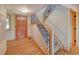 Bright foyer features hardwood floors, a staircase with decorative iron railings, and a wood front door at 3966 Bosque Ct, Boulder, CO 80301