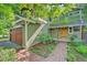 Front exterior view featuring a brick pathway, wood-paneled garage door, and hanging flower basket at 3966 Bosque Ct, Boulder, CO 80301