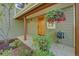 A covered front porch entry featuring a wood door, hose and flourishing plant at 3966 Bosque Ct, Boulder, CO 80301