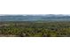 Breathtaking view of a neighborhood nestled among trees, mountains in the distance at 6470 Field St, Arvada, CO 80004