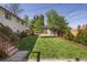Spacious backyard featuring lush lawn, storage shed, mature trees, and privacy fence at 6470 Field St, Arvada, CO 80004