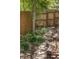 Stone pathway leads to a wooden gate, surrounded by lush greenery in the backyard at 6470 Field St, Arvada, CO 80004