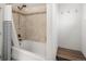 Updated bathtub and shower featuring tile surround and a classic shower curtain. There is a bench in the corner at 6470 Field St, Arvada, CO 80004