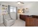 Bright Bedroom features a gray armchair, wood dresser, crib, and bookshelves at 6470 Field St, Arvada, CO 80004