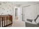 Cozy Bedroom with wooden crib and comfortable gray armchair and playful tree decor at 6470 Field St, Arvada, CO 80004