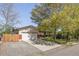 Inviting home with a large driveway, a well-maintained lawn, and mature trees at 6470 Field St, Arvada, CO 80004