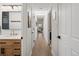 Hallway view showcases hardwood floors, skylights, and leads to a modern bathroom with wood vanity at 6470 Field St, Arvada, CO 80004