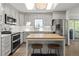 Bright kitchen boasts stainless steel appliances, white cabinetry, subway tile backsplash, and wood-top center island at 6470 Field St, Arvada, CO 80004