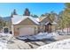 Two-story house with attached garage, snow covered yard at 23148 Pawnee Rd, Indian Hills, CO 80454