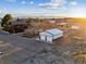 Aerial view featuring a home, outbuildings, and a large open field at sunset at 9703 Phillips Rd, Lafayette, CO 80026