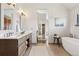 Bathroom featuring double sink vanity, a soaking tub, and neutral decor at 9703 Phillips Rd, Lafayette, CO 80026