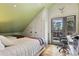 Bright bedroom with light hardwood floors, desk, and a door to the outdoor balcony at 9703 Phillips Rd, Lafayette, CO 80026