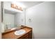 Simple bathroom with dark vanity, single sink, and mirror at 15892 E Arkansas Pl, Aurora, CO 80017