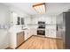 Bright kitchen featuring stainless steel appliances, light countertops, wood flooring, and skylight at 15892 E Arkansas Pl, Aurora, CO 80017