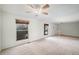 Expansive living room bathed in natural light, featuring neutral carpet and ceiling fan at 15892 E Arkansas Pl, Aurora, CO 80017