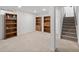 Spacious basement with bookshelves and carpeted floor next to stairs at 2165 S Flower St, Lakewood, CO 80227