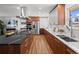 Modern kitchen featuring stainless steel appliances, a black marble island, and elegant wood cabinets at 2165 S Flower St, Lakewood, CO 80227