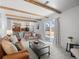 Bright living room with exposed beams, a neutral palette, and sliding glass doors to the backyard at 2165 S Flower St, Lakewood, CO 80227