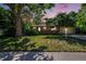 Charming home with a well-manicured lawn and mature trees at sunset at 6780 Allison St, Arvada, CO 80004