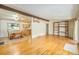 Open floor plan featuring hardwood floors, a built-in bookshelf, and a dining area with ample natural light at 6780 Allison St, Arvada, CO 80004