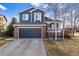 Charming two-story home with a brick facade, blue siding, and well-maintained front yard at 11899 Elizabeth Cir, Thornton, CO 80233