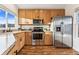 Modern kitchen boasting stainless steel appliances, wooden cabinets, and granite countertops at 11899 Elizabeth Cir, Thornton, CO 80233