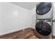Laundry room featuring stacked washer and dryer, and hardwood style floors at 11899 Elizabeth Cir, Thornton, CO 80233