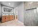 Bathroom with wood vanity, backlit mirror and tiled walk-in shower at 8750 W 8Th Ave, Lakewood, CO 80215