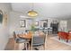 Dining room with a modern light fixture, hardwood floors, stylish decor, and an open view to the kitchen at 8750 W 8Th Ave, Lakewood, CO 80215