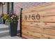 Close-up of the house number displayed on a modern wooden screen with elegant planter at 8750 W 8Th Ave, Lakewood, CO 80215