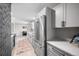 Spacious kitchen featuring white cabinets, stainless steel appliances and brick accent wall at 8750 W 8Th Ave, Lakewood, CO 80215
