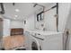 Bright laundry room with modern appliances, hardwood floors, and a vintage wooden dresser at 8750 W 8Th Ave, Lakewood, CO 80215