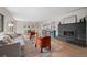 Comfortable living room with a fireplace, hardwood floors, stylish seating, and access to the kitchen and dining area at 8750 W 8Th Ave, Lakewood, CO 80215