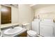 A bathroom featuring sink, toilet, washer, and dryer at 1250 S Monaco Pkwy # 67, Denver, CO 80224