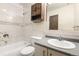 Cozy bathroom featuring a white vanity, tile walls, a bathtub and dark wood cabinet above toilet at 1250 S Monaco Pkwy # 67, Denver, CO 80224