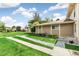 Townhome exterior with well-maintained lawn, stone accents, and mature landscaping at 1250 S Monaco Pkwy # 67, Denver, CO 80224