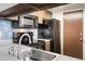 A kitchen featuring tile backsplash, oven, microwave, cabinets, and refrigerator at 1250 S Monaco Pkwy # 67, Denver, CO 80224