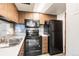 A kitchen featuring tile backsplash, oven, microwave, cabinets, and refrigerator at 1250 S Monaco Pkwy # 67, Denver, CO 80224