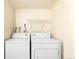 A laundry area featuring washer, dryer, and wire rack at 1250 S Monaco Pkwy # 67, Denver, CO 80224