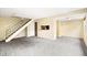 Bright living room featuring neutral paint, new gray carpeting, and a stairwell at 1250 S Monaco Pkwy # 67, Denver, CO 80224