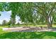 Park area with BBQ pit, picnic tables, a large tree, and green grass at 1250 S Monaco Pkwy # 67, Denver, CO 80224