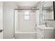 Bright bathroom features white tiled tub, shower, vanity, and fixtures at 2930 S Birch St, Denver, CO 80222