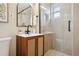 Modern bathroom features a vanity with wicker-style doors, black faucet, and glass-enclosed shower at 2930 S Birch St, Denver, CO 80222