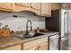 Close-up of the stainless steel refrigerator and sink in a functional kitchen at 2930 S Birch St, Denver, CO 80222